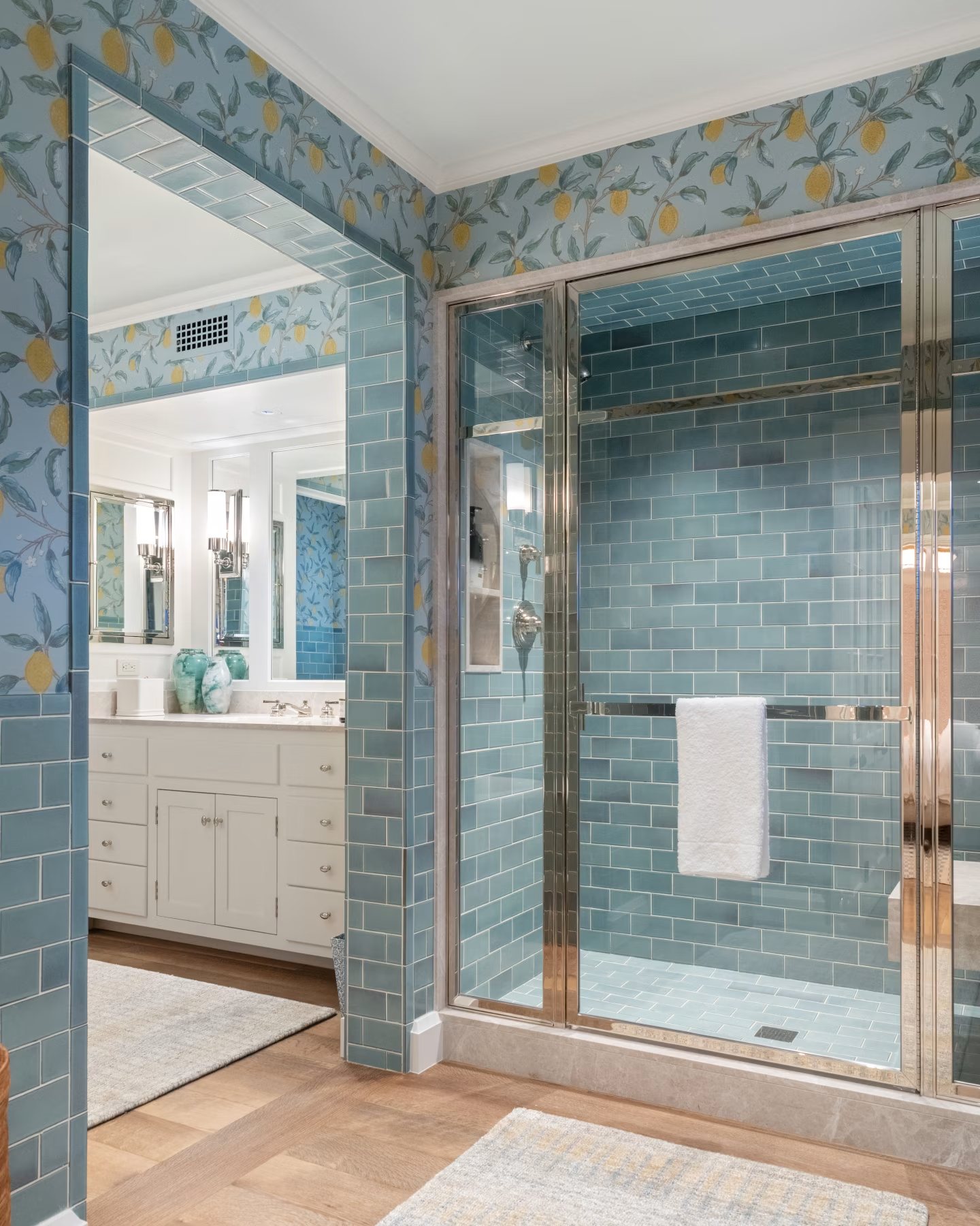 Bath in blue subway tile and lemon wallpaper