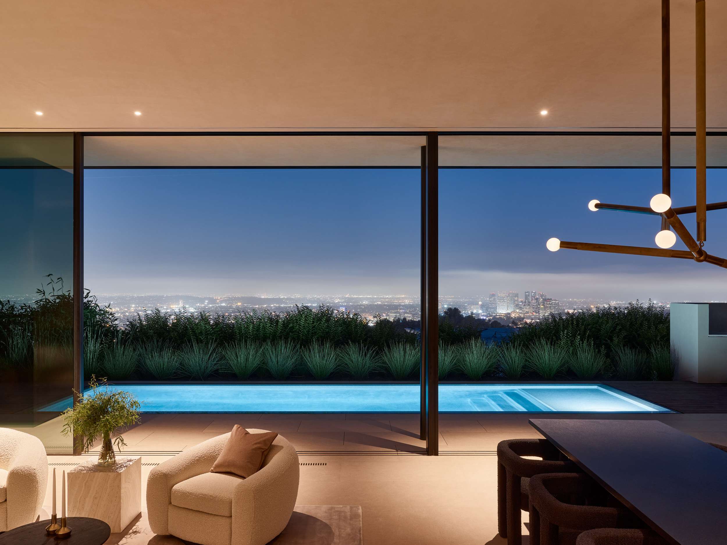 Living room and pool at night over the city